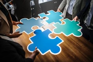 People holding large jigsaw pieces